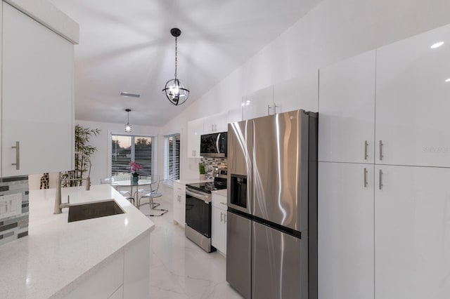 kitchen featuring decorative backsplash, stainless steel appliances, sink, decorative light fixtures, and white cabinets