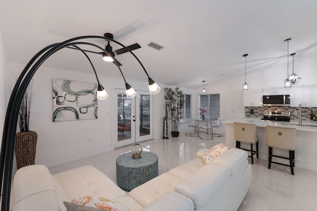 living room with ceiling fan and french doors