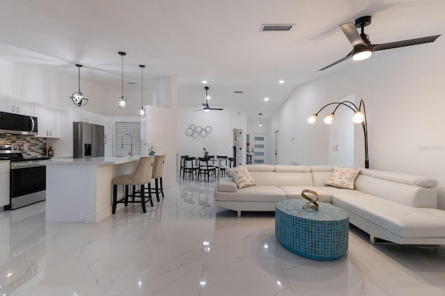 living room with ceiling fan and sink