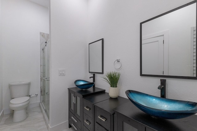 bathroom with a shower with door, vanity, and toilet