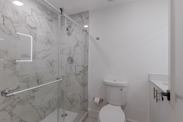 bathroom featuring an enclosed shower, vanity, and toilet