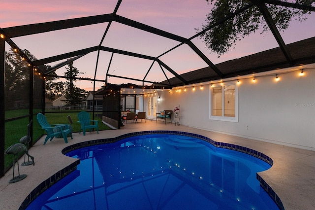 pool at dusk featuring glass enclosure and a patio area