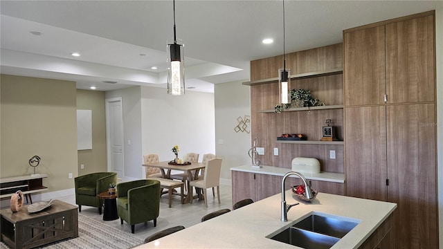 kitchen with sink, light hardwood / wood-style floors, and decorative light fixtures