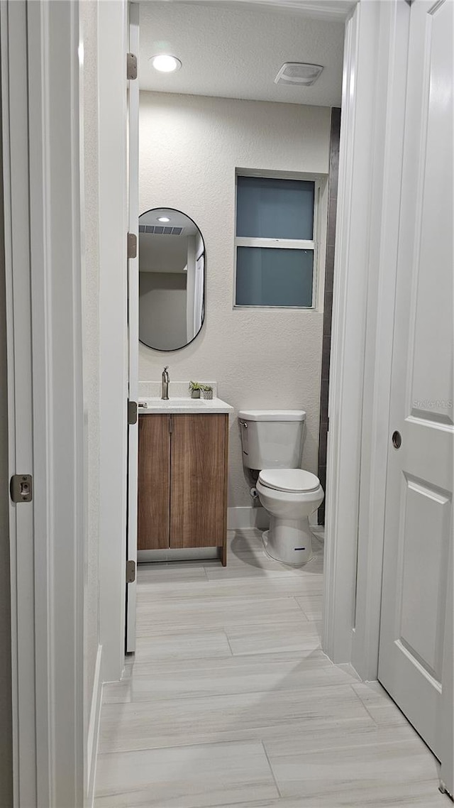 bathroom with vanity, wood-type flooring, and toilet