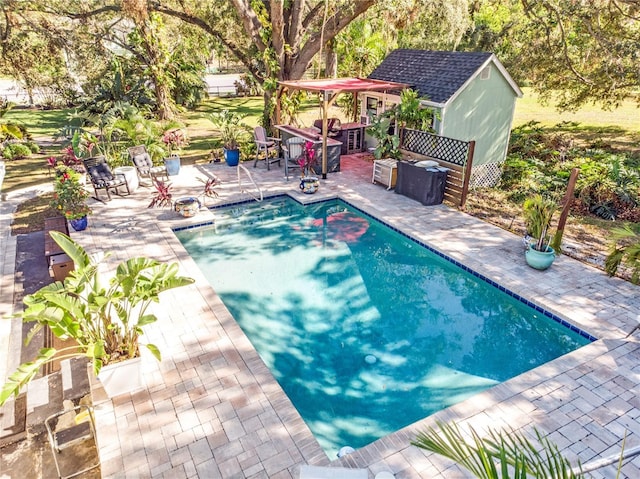 pool with a patio area, a storage shed, and an outdoor structure