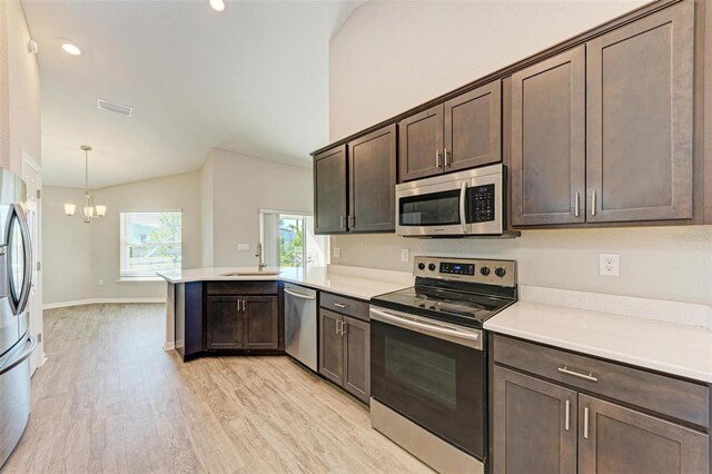 3030 58th Way E, Palmetto, FL 34221 - kitchen with stainless steel appliances, lofted ceiling, a sink, a peninsula, and dark brown cabinetry