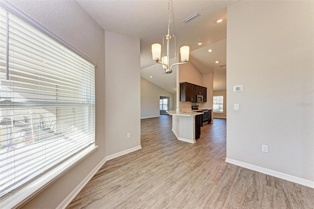 3030 58th Way E, Palmetto, FL 34221 - kitchen with stainless steel appliances, light wood-style floors, dark brown cabinets, light countertops, and a chandelier