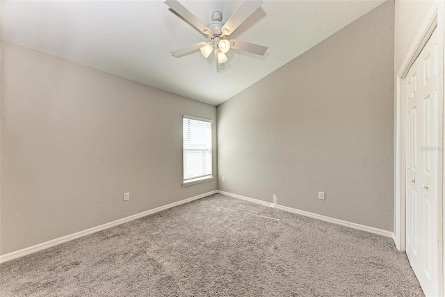 carpeted empty room with vaulted ceiling and ceiling fan