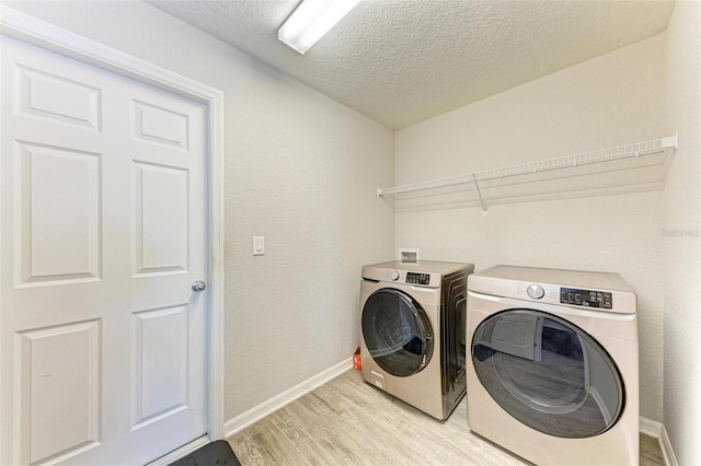 3030 58th Way E, Palmetto, FL 34221 - laundry room featuring light wood-style flooring, baseboards, separate washer and dryer, a textured ceiling, and a textured wall
