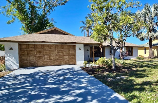 single story home featuring a front lawn and a garage