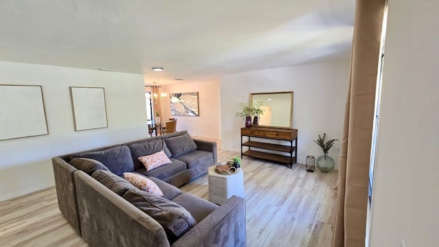 living room with light hardwood / wood-style flooring and an inviting chandelier