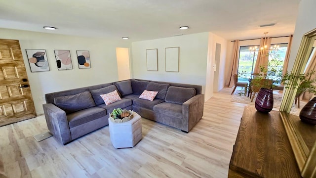 living room with light hardwood / wood-style flooring and a chandelier