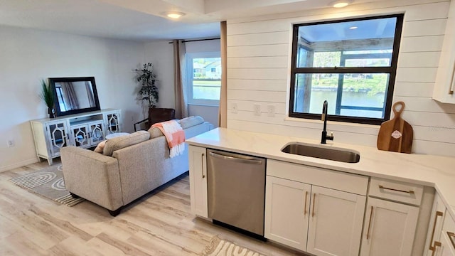 living room with sink, a healthy amount of sunlight, and light hardwood / wood-style flooring