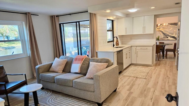 living room with light hardwood / wood-style flooring and sink