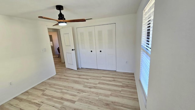 unfurnished bedroom featuring ceiling fan, light hardwood / wood-style flooring, and a closet