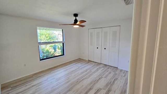 unfurnished bedroom with a closet, light hardwood / wood-style floors, and ceiling fan