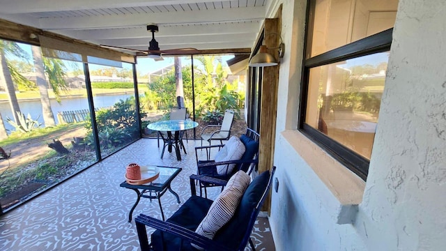 sunroom / solarium with beamed ceiling, a water view, and ceiling fan