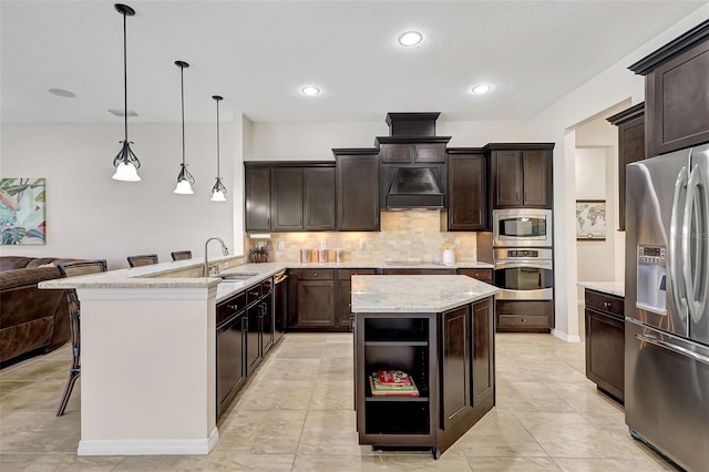 17113 1st Dr E, Bradenton, FL 34212 - kitchen with kitchen peninsula, appliances with stainless steel finishes, a kitchen bar, dark brown cabinetry, and pendant lighting