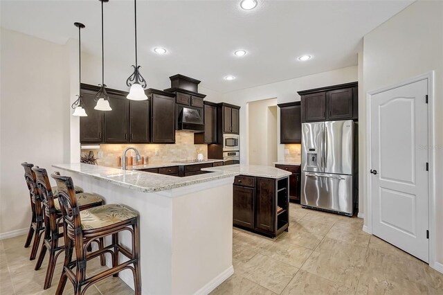17113 1st Dr E, Bradenton, FL 34212 - kitchen featuring pendant lighting, light stone countertops, appliances with stainless steel finishes, tasteful backsplash, and kitchen peninsula