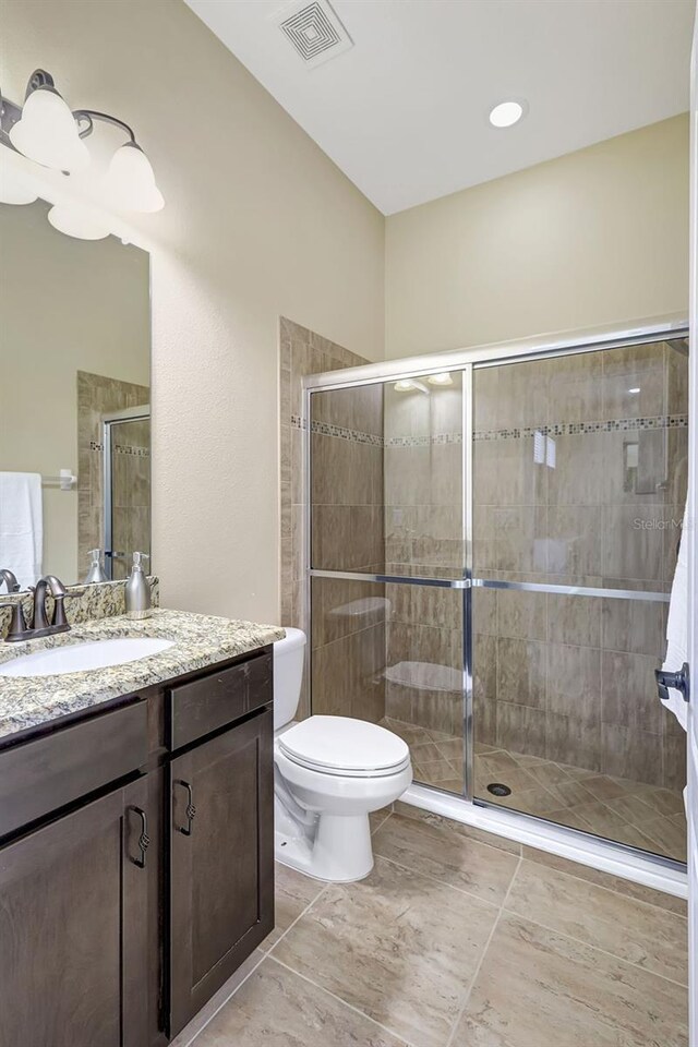 17113 1st Dr E, Bradenton, FL 34212 - bathroom with tile patterned floors, vanity, toilet, and an enclosed shower