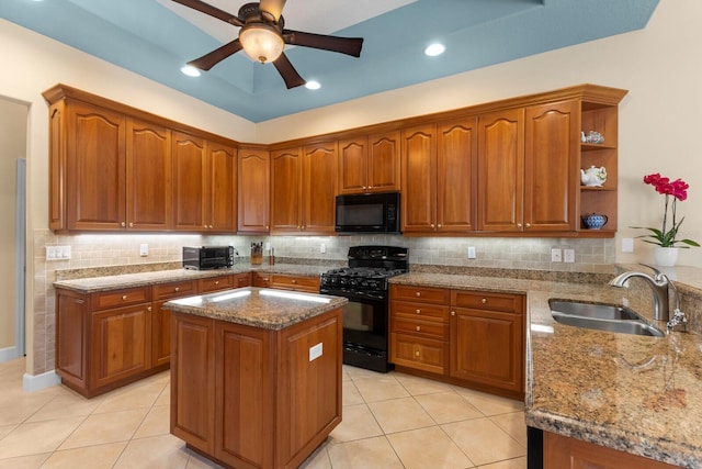 kitchen featuring light stone countertops, sink, ceiling fan, decorative backsplash, and black appliances