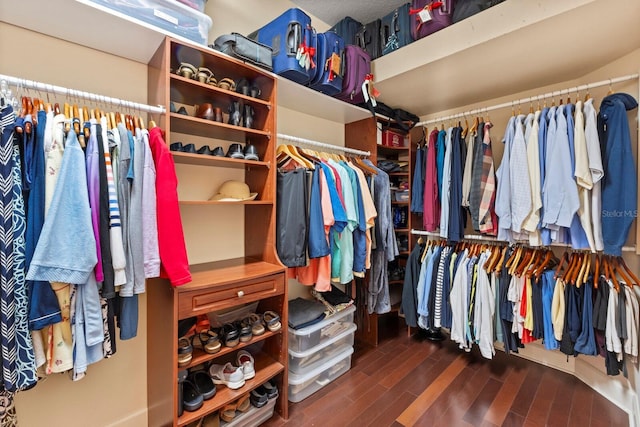 walk in closet with dark wood-type flooring