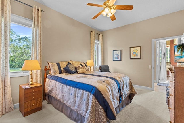 bedroom featuring multiple windows, ceiling fan, and light carpet