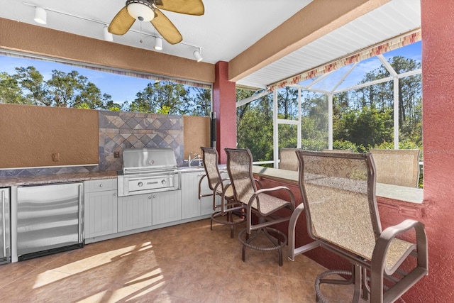 sunroom featuring rail lighting and ceiling fan