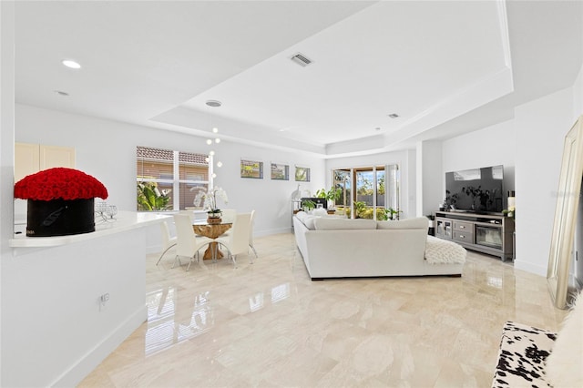 living room featuring a tray ceiling and plenty of natural light