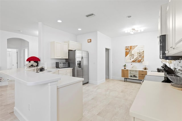 kitchen featuring kitchen peninsula, stainless steel fridge with ice dispenser, white cabinetry, and sink