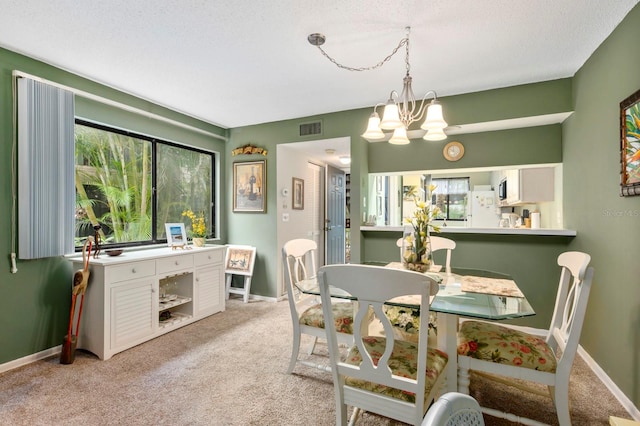 carpeted dining space with a textured ceiling and a notable chandelier