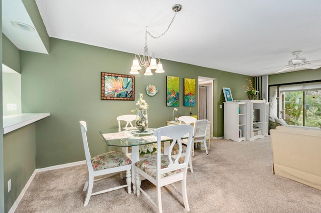 dining area with ceiling fan with notable chandelier and carpet floors