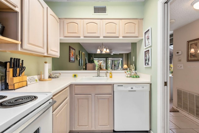 kitchen with sink, tile patterned flooring, a chandelier, a textured ceiling, and white appliances