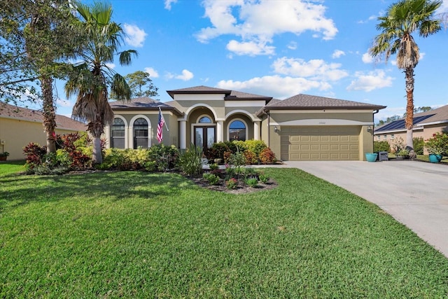 mediterranean / spanish house with a garage and a front lawn