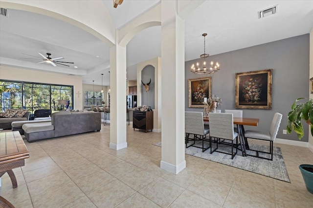 tiled dining space featuring ceiling fan with notable chandelier