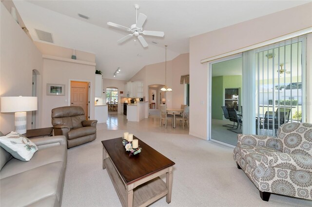 living room with plenty of natural light, ceiling fan, light carpet, and high vaulted ceiling