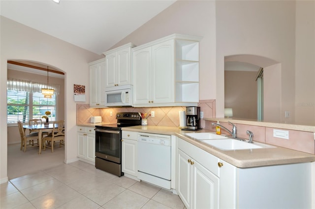 kitchen with tasteful backsplash, white appliances, vaulted ceiling, sink, and white cabinets