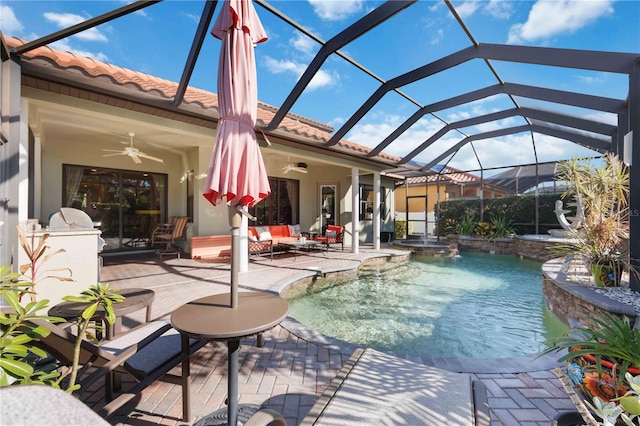 view of swimming pool featuring pool water feature, ceiling fan, a lanai, and a patio