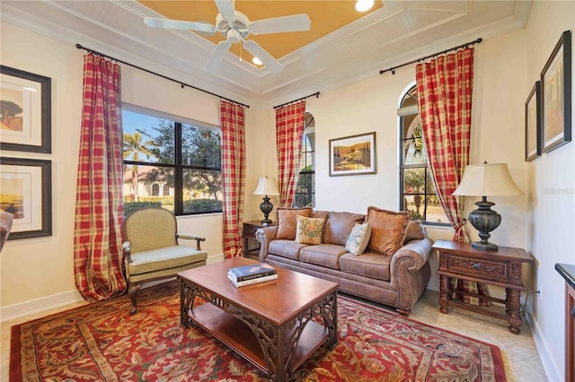 tiled living room with ceiling fan and crown molding