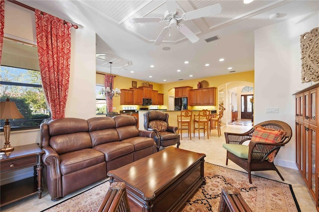 living room featuring ceiling fan with notable chandelier