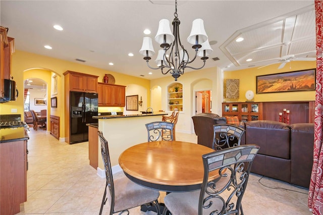 tiled dining space with built in shelves and ceiling fan with notable chandelier