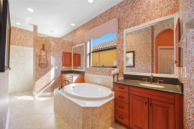 bathroom featuring tile patterned floors, tiled bath, and vanity