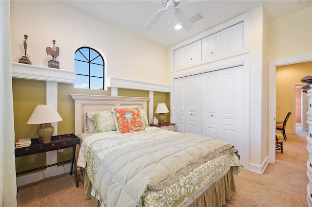 carpeted bedroom featuring a towering ceiling, a closet, and ceiling fan