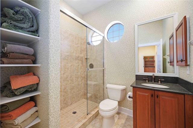 bathroom featuring vanity, toilet, and a shower with shower door