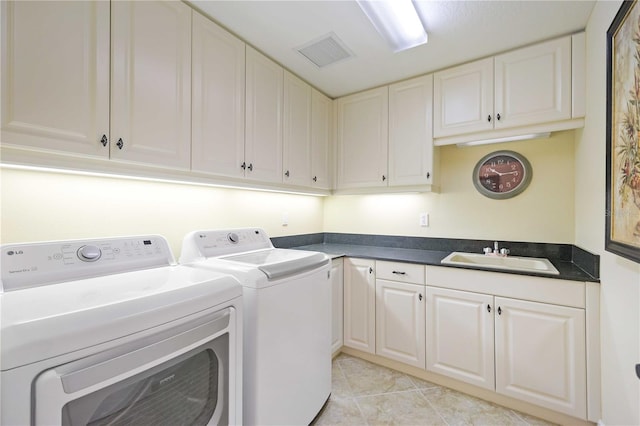 laundry area featuring light tile patterned flooring, washer and clothes dryer, cabinets, and sink