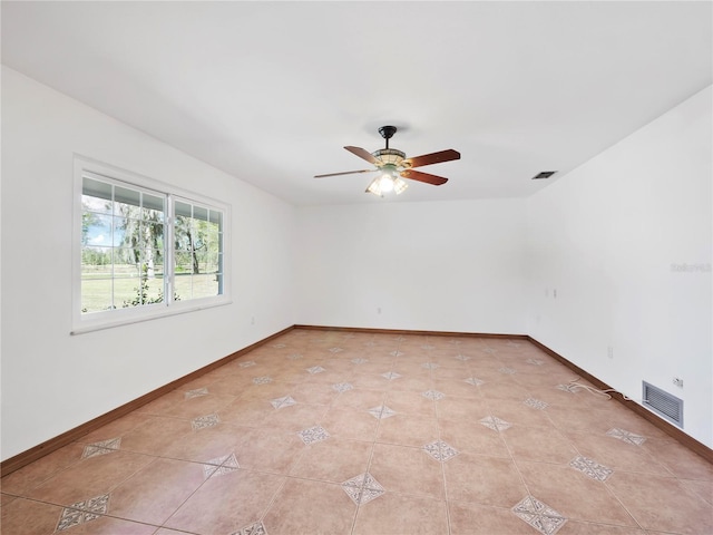 tiled spare room with ceiling fan