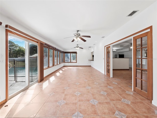 unfurnished room featuring light tile patterned floors, french doors, and plenty of natural light