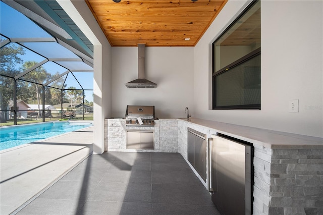 view of patio with area for grilling, glass enclosure, and exterior kitchen