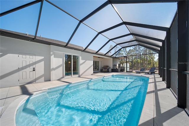 view of swimming pool featuring a patio area and a lanai