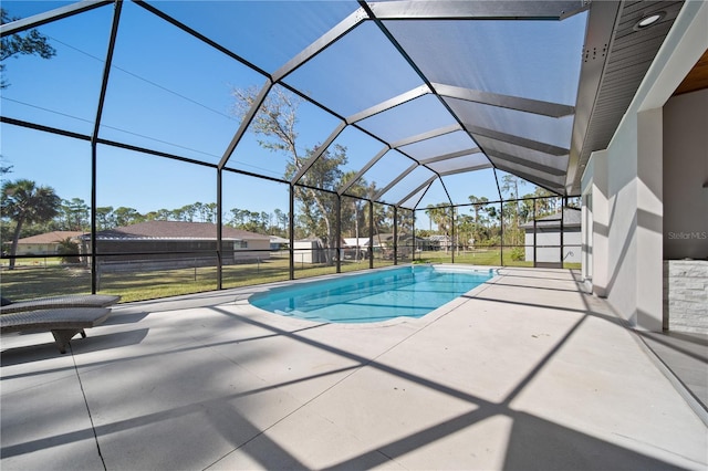 view of pool with a lanai, a patio area, and a yard